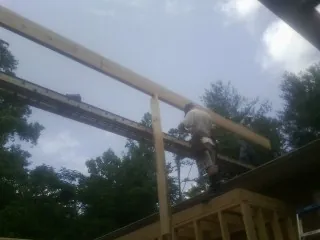 Carpenter setting a ridge beam over a new addition frame — Ice Dam Removal by Roofing Brothers in Random Lake