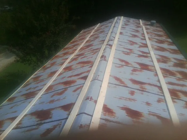Rusted metal roof panels with new wood purlins before replacement — Storm Damage Roof Repair in Random Lake by Roofing Brothers
