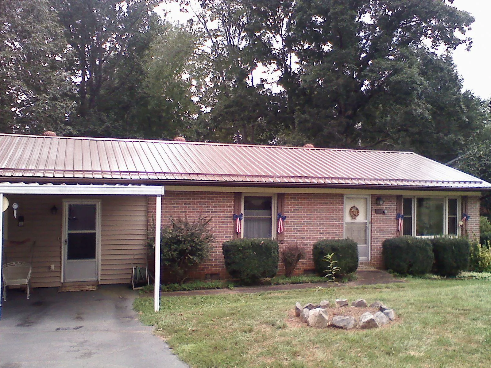 Bronze metal roof and carport on a brick ranch home — Roof Repair work by our crew in Random Lake