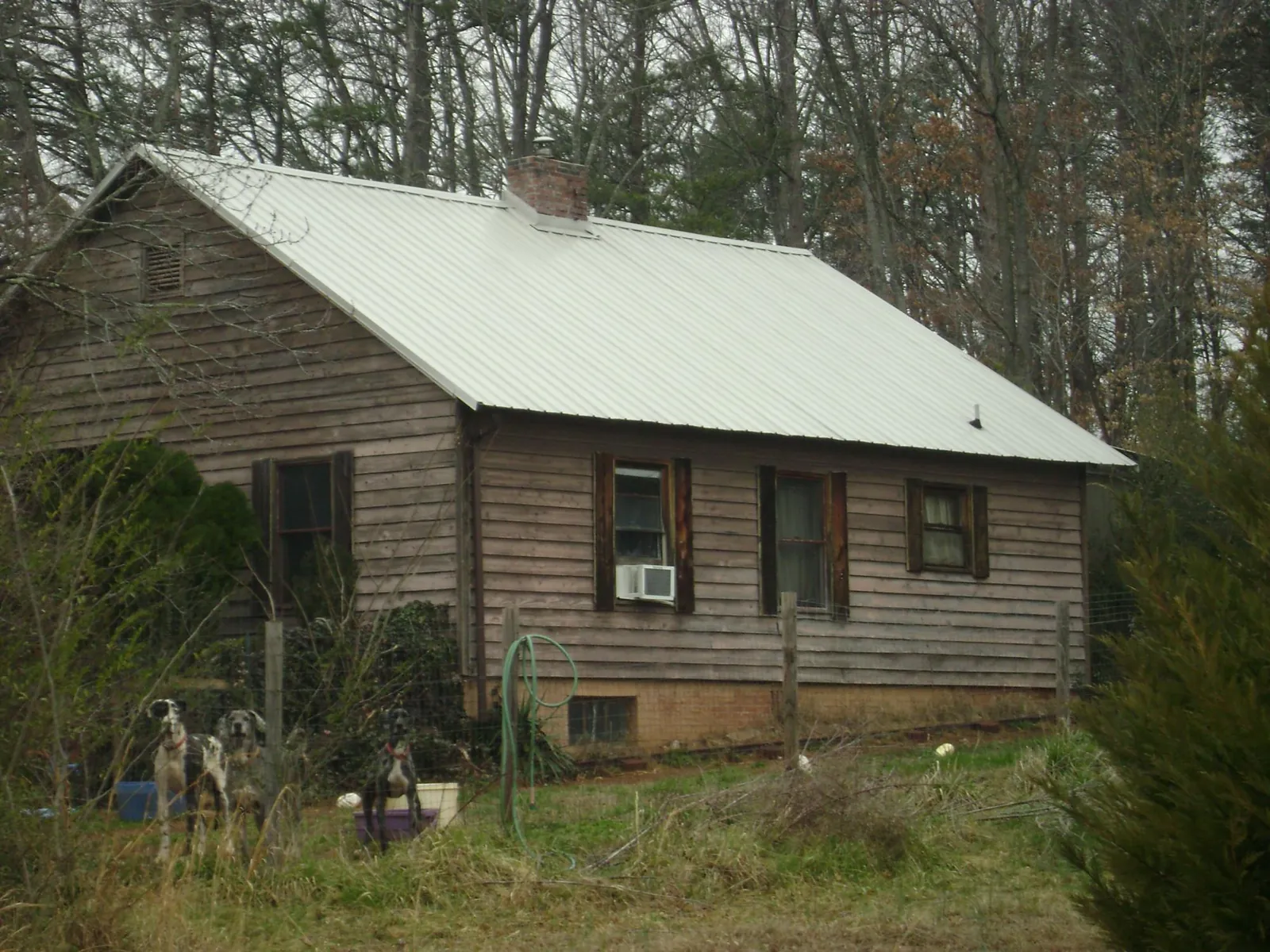 White metal roof on an old wood sided farmhouse, from a Metal Roof Installation job in Random Lake